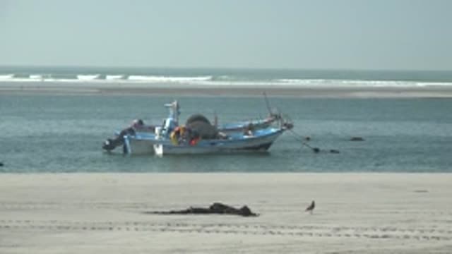 LA BOCANA BCS MEXICO-2022: Fishing Boat Anchored Near Sandy Shore With Ocean Waves