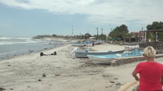 PUENTA ABREOJOS BCS MEXICO-2022: Beachgoers Walking Past Boats on Sandy Shore