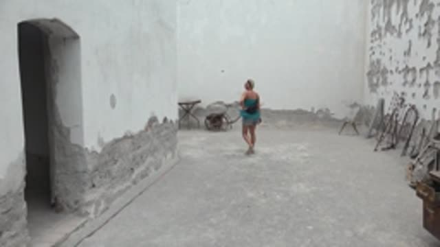 MULEGE BCS MEXICO-2022: Woman Walking in a Weathered White Courtyard