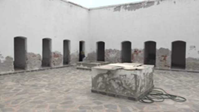MULEGE BCS MEXICO-2022: Person Moving Through Arched Doorways in a Stone Courtyard