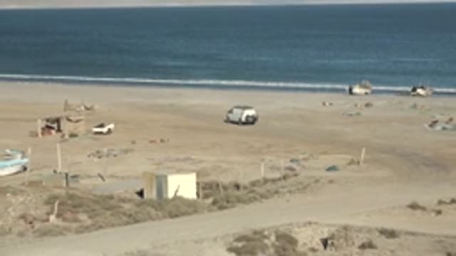 SAN JUANICO BCS MEXICO-2022: Sandy Beach with Boats and Vehicles, Camera Panning Out