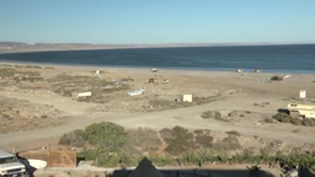 SAN JUANICO BCS MEXICO-2022: Vehicle Moving on Desert Beach with Tent Structures