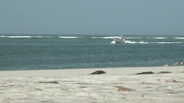 LA BOCANA BCS MEXICO-2022: Boat Moving Across Ocean Near Sandy Beach