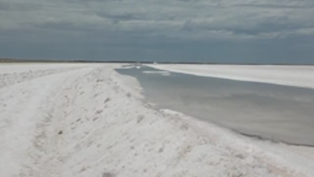 GUERRERO NEGRO BCS MEXICO-2022: Snow-Covered Path Beside Partially Frozen Water