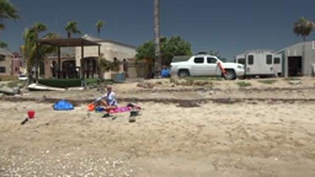SAN CARLOS BCS MEXICO-2022: Beachgoer Adjusting Items on Sandy Shore