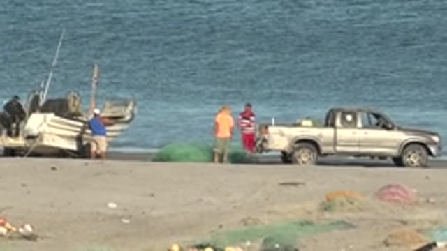 SAN JUANICO BCS MEXICO-2022: Fishermen Handling Nets on Sandy Shore