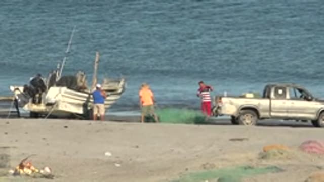 SAN JUANICO BCS MEXICO-2022: Fishermen Handling Nets on Sandy Shore