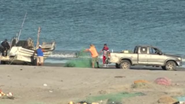 SAN JUANICO BCS MEXICO-2022: Fishermen Handling Nets on Sandy Beach