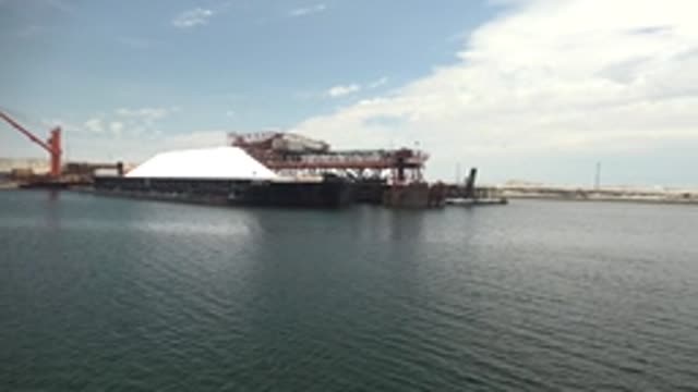 GUERRERO NEGRO BCS MEXICO-2022: Crane Moving Past Industrial Dock and Water