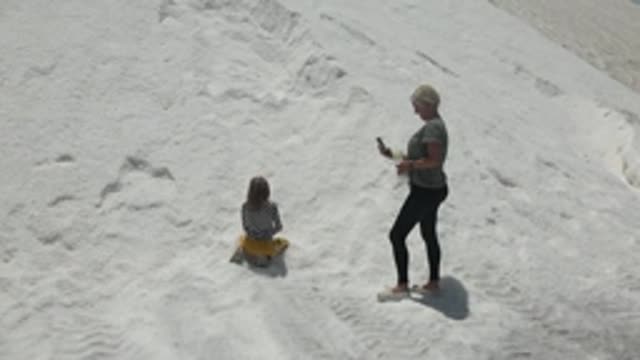 GUERRERO NEGRO BCS MEXICO-2022: Child and Adult Moving on White Salt Flat