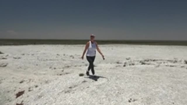 SAN CARLOS BCS MEXICO-2022: Woman Walking Across White Desert Landscape