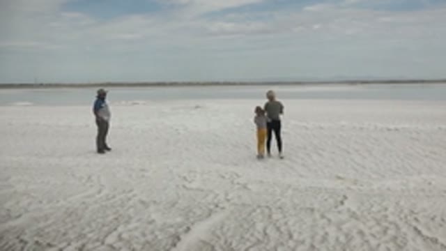 GUERRERO NEGRO BCS MEXICO-2022: Three People Walking Across Frozen Ice