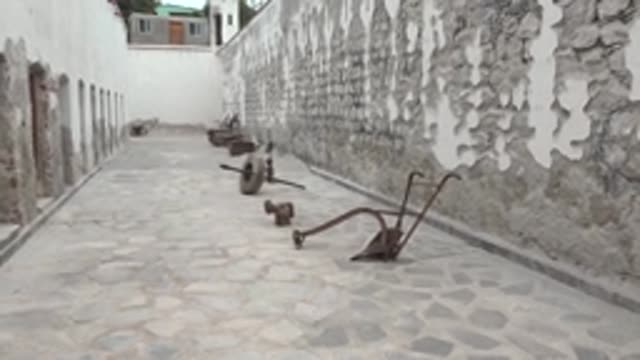 MULEGE BCS MEXICO-2022: Narrow Stone Courtyard with Peeling Walls and Cobblestone Path
