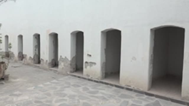 MULEGE BCS MEXICO-2022: Old Boat with Plant in Courtyard of White Building