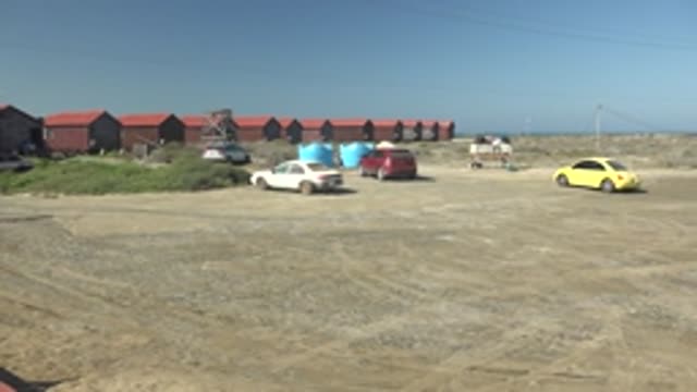 LA BOCANA BCS MEXICO-2022: Wooden Walkway with Red Railings Near Dirt Lot