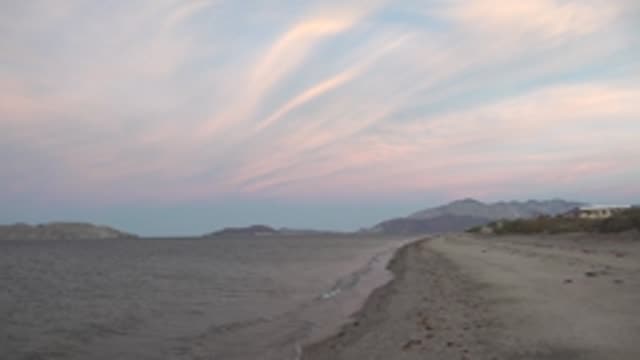 BAHIA DE LOS ANGELES BCS MEXICO-2022: Calm Ocean Waves on Sandy Beach at Dusk