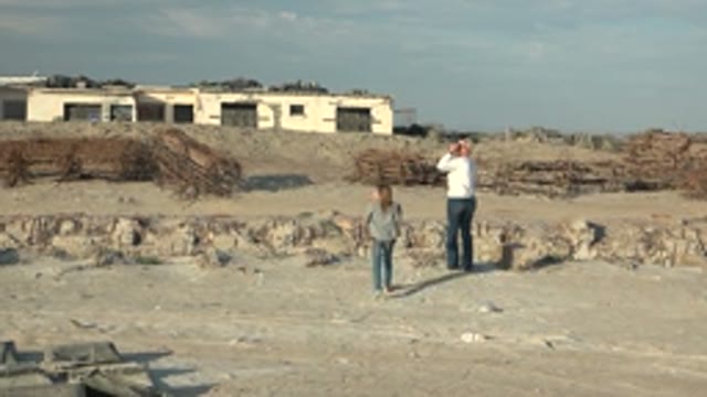 GUERRERO NEGRO BCS MEXICO-2022: Woman Approaches Man Taking Photo at Construction Site