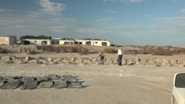 GUERRERO NEGRO BCS MEXICO-2022: Child and Adult Approaching Camera at Rubble Site