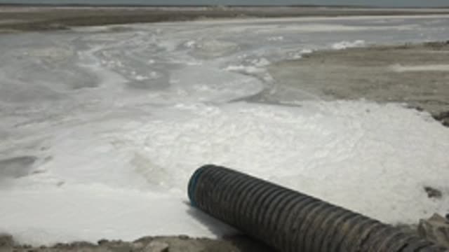 GUERRERO NEGRO BCS MEXICO-2022: Industrial Pipe Discharging Foamy Water Into Lagoon