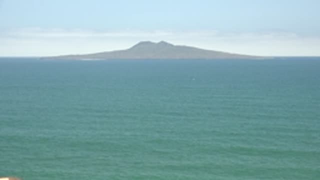 SAN QUINTIN BC MEXICO-2022: Distant Mountain Island with Moving Boats on Calm Ocean