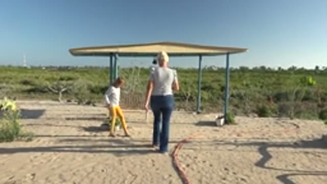 SAN CARLOS BCS MEXICO-2022: Woman and Child Approaching a Shaded Shelter on Sand