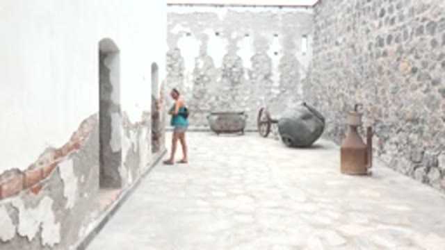 MULEGE BCS MEXICO-2022: Woman Taking Photo in Historic Stone Courtyard