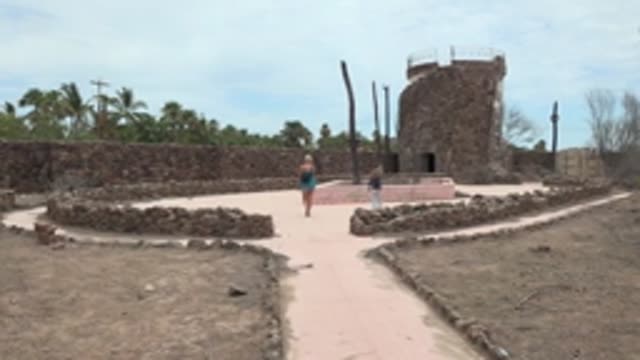 MULEGE BCS MEXICO-2022: People Walking Toward Stone Tower in Dry Courtyard