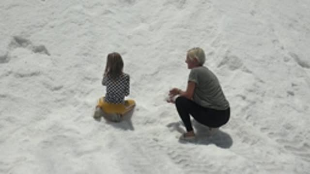 GUERRERO NEGRO BCS MEXICO-2022: Child on Yellow Sled with Adult in Snow