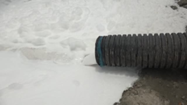 GUERRERO NEGRO BCS MEXICO-2022: Corrugated Hose Releasing White Foam on Snowy Surface