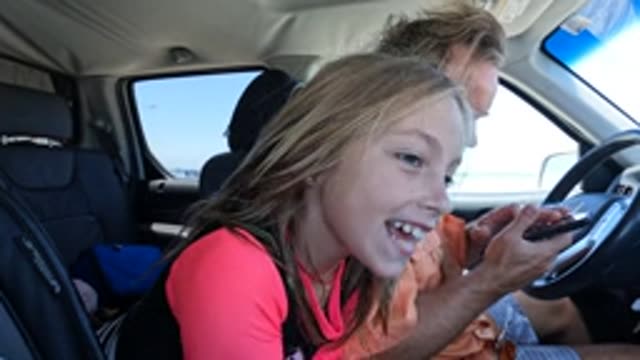 BAJA CALIFORNIA MEXICO-2022: Girl in Car Smiling and Shifting Gaze with Driver