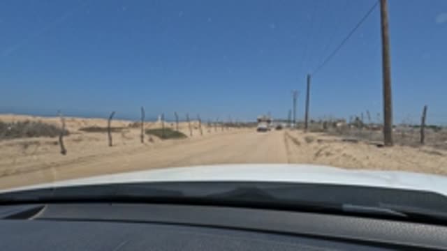 BAJA CALIFORNIA MEXICO-2022: Car Driving on a Sandy Desert Road with Oncoming Traffic