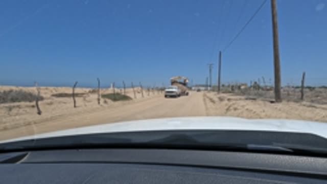 BAJA CALIFORNIA MEXICO-2022: Car Approaching a Truck on a Sandy Road