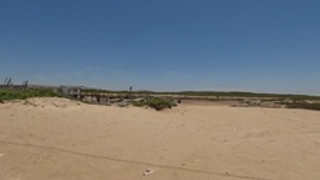 BAJA CALIFORNIA MEXICO-2022: Sandy Landscape with Parked Vehicles and Industrial Structures