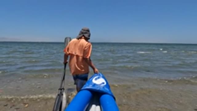 BAJA CALIFORNIA MEXICO-2022: Person Preparing Inflatable Boat at Shoreline