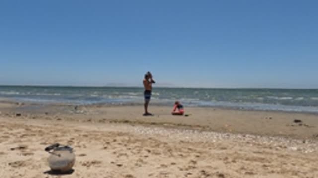 BAJA CALIFORNIA MEXICO-2022: Two People on a Sandy Beach by the Ocean