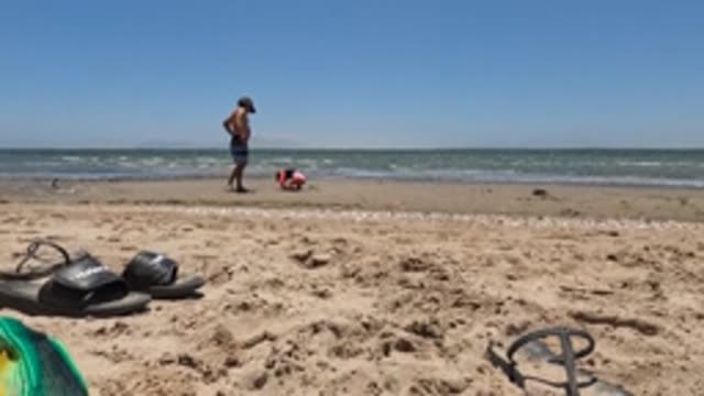 BAJA CALIFORNIA MEXICO-2022: Shirtless Man Adjusting Hat on Sandy Beach
