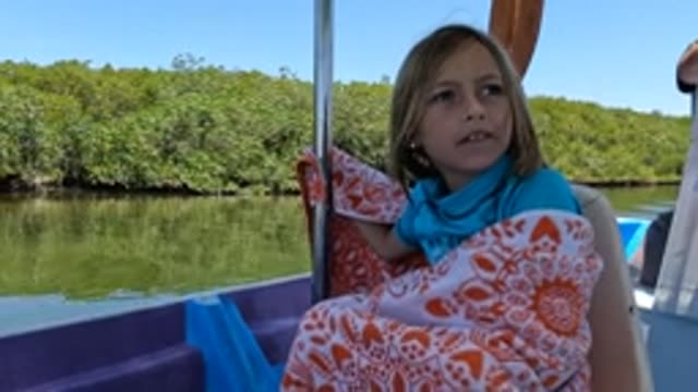BAJA CALIFORNIA MEXICO-2022: Child on Boat Observing Riverbank Greenery