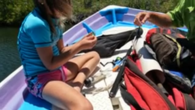 BAJA CALIFORNIA MEXICO-2022: Girl and Adult Handling a Small Fish on a Boat