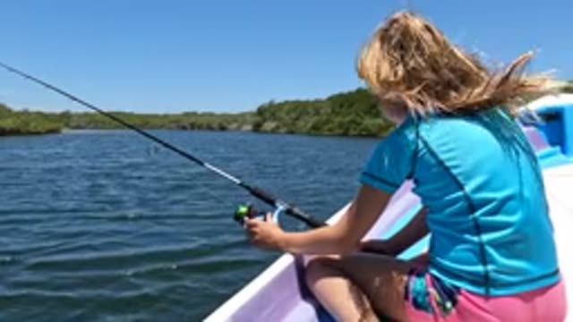 BAJA CALIFORNIA MEXICO-2022: Girl Fishing From a Boat on Calm Water