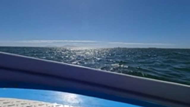 BAJA CALIFORNIA MEXICO-2022: Boat Railing View of Sunlit Ocean Waves