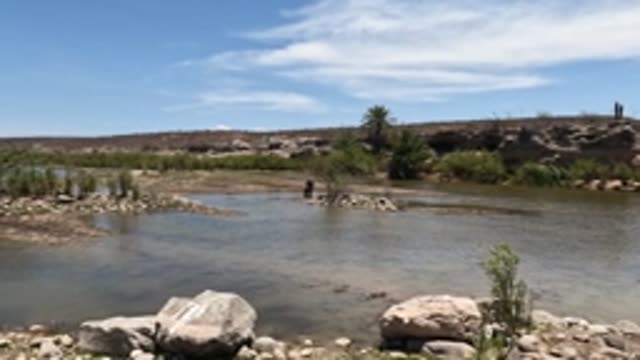 BAJA CALIFORNIA MEXICO-2022: Person Wading in Shallow River with Rocky Banks