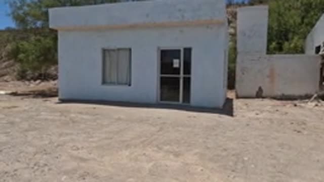 BAJA CALIFORNIA MEXICO-2022: Panning View of Small White Building in Dry Landscape