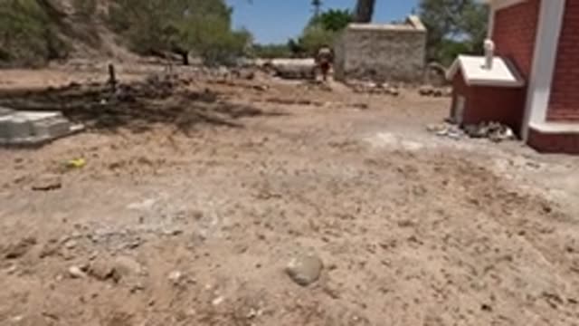 BAJA CALIFORNIA MEXICO-2022: Arid Cemetery with White Tombstones and Red Brick Building