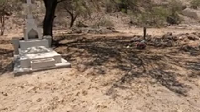 BAJA CALIFORNIA MEXICO-2022: Desert Cemetery with Stone Graves and Scattered Flowers