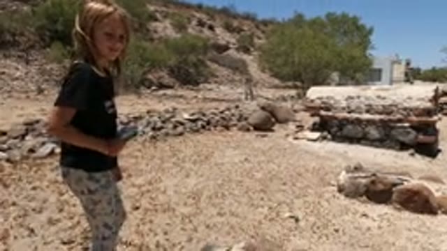 BAJA CALIFORNIA MEXICO-2022: Child in Arid Yard with Stone Structures