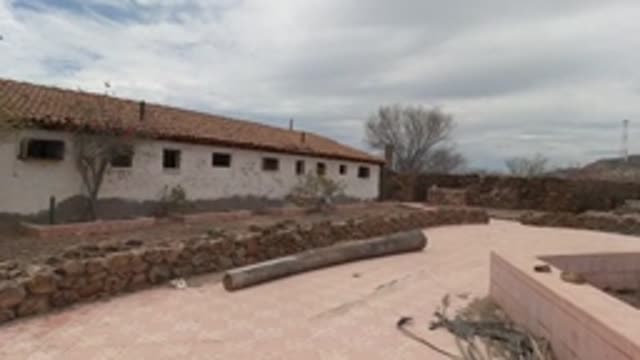 BAJA CALIFORNIA MEXICO-2022: Panning View of White Building and Stone-walled Courtyard