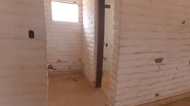 BAJA CALIFORNIA MEXICO-2022: Person Moving Through Brick-Walled Room Into Tiled Space