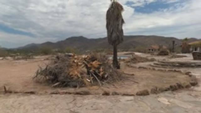 BAJA CALIFORNIA MEXICO-2022: Child Walking in Desert Courtyard with Adobe Building