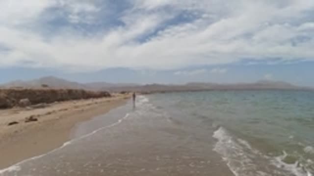 BAJA CALIFORNIA MEXICO-2022: Gentle Ocean Waves on a Sandy Beach with a Person