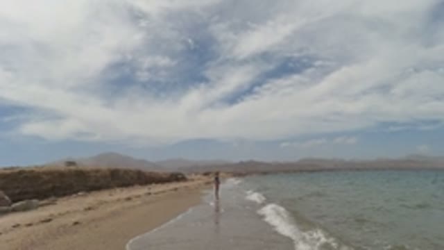 BAJA CALIFORNIA MEXICO-2022: Person on Sandy Beach with Gentle Ocean Waves